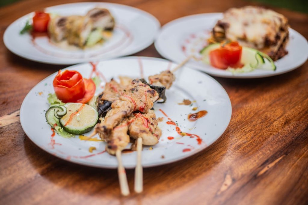 Delicious grilled skewers beautifully plated with garnishes on a wooden table.