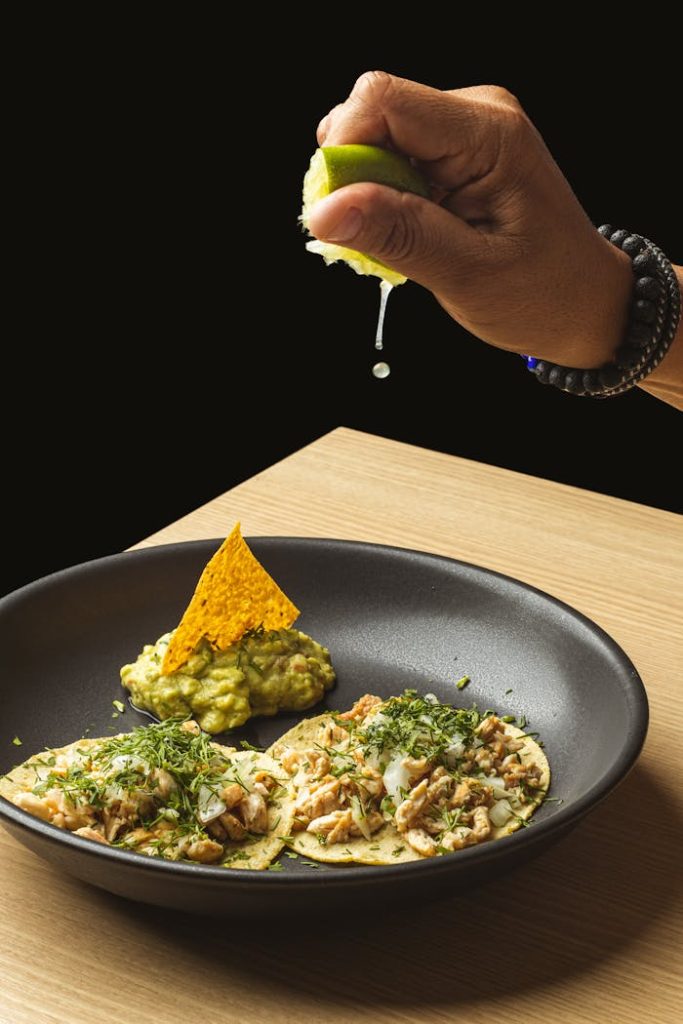 Appetizing tacos with lime juice and guacamole, perfect for Mexican cuisine lovers.